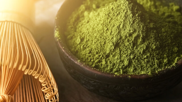 Matcha green tea powder in a bowl with a whisk for whipping