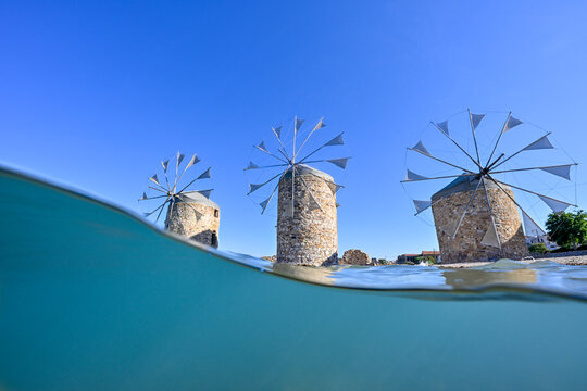 Half underwater image of historical windmills of Chios Island, Greece