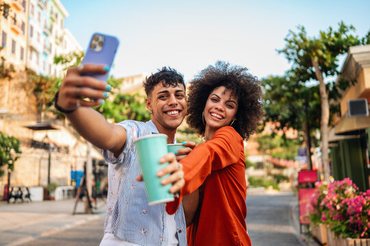 Young students relaxing and enjoying a city break, using their mobile phone to capture a moment