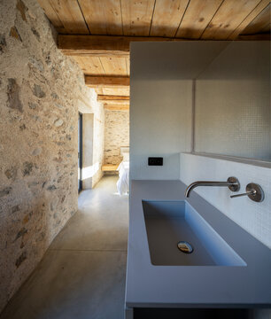 Close-up of a sink in a bedroom with stone walls. Everything is new and restored.