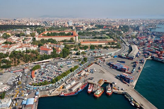 Aerial view of the historic Selimiye Barracks and the busy Harem port area with cargo ships, parking lots, and urban cityscape in Uskudar, Istanbul, Turkey.