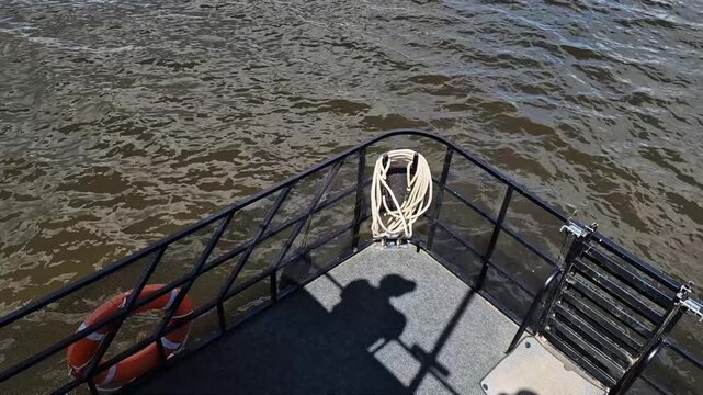 High angle view of riverboat bow with shadow of person in cap. Concept: river excursion tourism