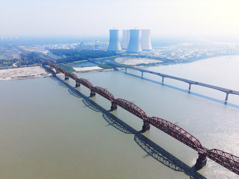 Aerial view of the historic Hardinge Bridge spanning the Padma River with the Rooppur Nuclear Power Plant cooling towers in the background in Pabna, Rajshahi Division, Bangladesh.