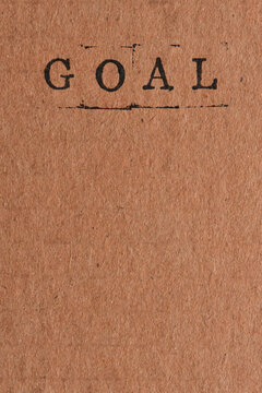 Word GOAL stamped at top vertical craft paper background leaving copy space below.