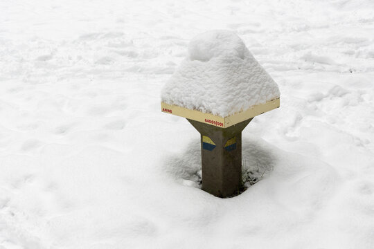 Dutch mushroom-shaped cycle route sign (known locally as an ANWB paddenstoel) is a low concrete wayfinding marker used to indicate cycling and walking routes. Now covered by snow.