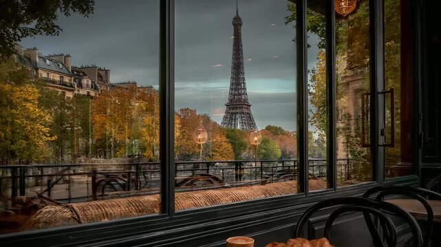Paris, France, Europe. A detailed, atmospheric photograph of a Parisian cafe with a panoramic view of the Eiffel Tower in the background. The cafes interior features a table with a croissant.