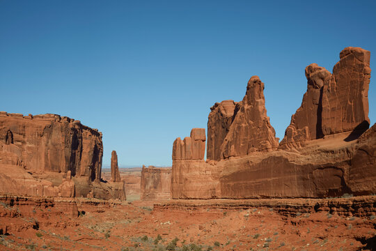 Eroded sandstone spires rising above a narrow desert corridor