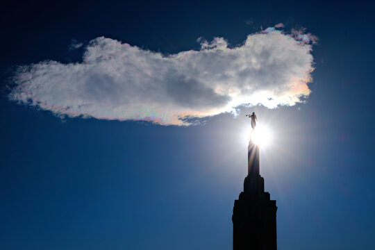 Steeple with Angel Moroni on Mormon or LDS or Latter Day Saints Temple with Sunstar for Holiness and Cloud in Sky