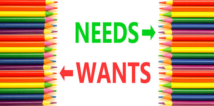 Needs instead wants words symbol. Concept words Needs Wants on beautiful white paper. Beautiful white background. Colored pencils. Business psychology needs or wants concept. Copy space.