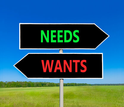 Needs instead wants words symbol. Concept words Needs Wants on beautiful black road sign. Beautiful blue sky background. Business psychology needs or wants concept. Copy space.