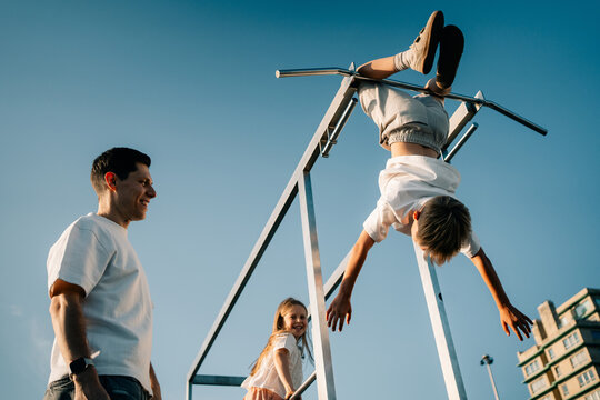 Father and Children Play at the Park in the Afternoon Sun