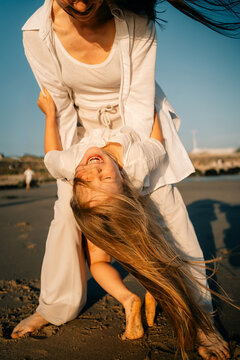 Mother and Child Having Fun Together at the Beach During Sunset