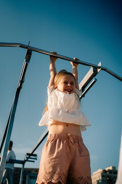 Child Plays on Outdoor Equipment at Park During Sunny Day