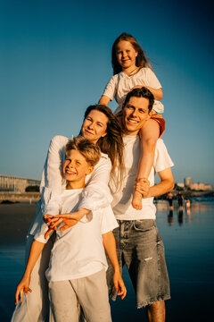 Family Enjoys Time at Beach in Golden Sunlight During Summer Day