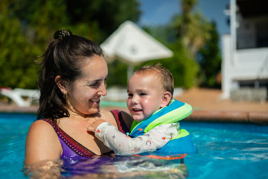 Mother holding toddler in swimming pool