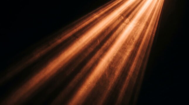 Golden light beams on black background. Abstract rays of warm light in dark space.
