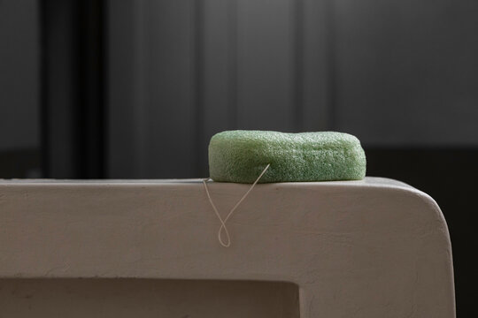 A body cleansing sponge on shower shelf