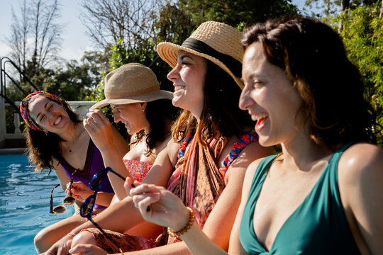 Women friends laughing by pool