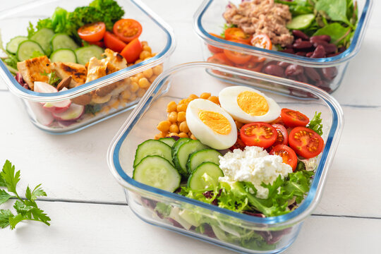 Three glass meal prep containers with salad