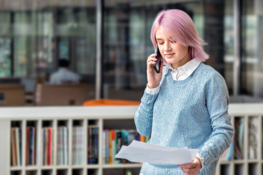 Young businesswoman with pink hair calling phone