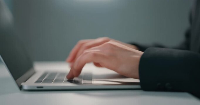 Focused person typing on laptop keyboard