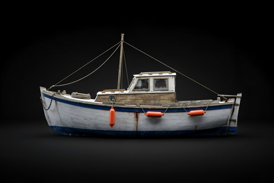 Small fishing boat with orange fenders at anchor during twilight with dramatic lighting