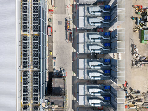 Aerial view of a data center facility featuring rows of industrial cooling units and server infrastructure on a construction site in the United Kingdom.