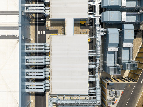 Aerial view of a modern data center facility featuring complex rooftop HVAC systems, cooling units, and service infrastructure in the United Kingdom.