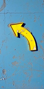 Yellow Curved Direction Arrow on Weathered Blue Wall