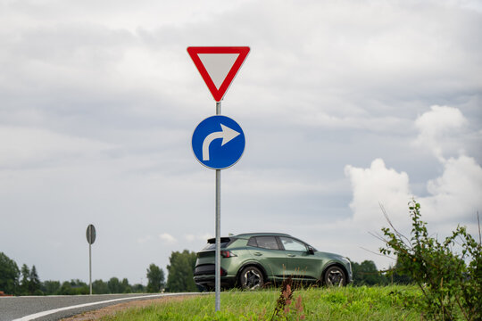 Inverted triangular yield sign and blue round right turn mandatory sign regulating vehicle traffic direction and safety