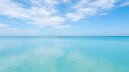 Fototapeta premium Blue Tropical Seascape with Clear Blue Sky, Turquoise Ocean, Sandy Beach, Fluffy Clouds and Peaceful Horizon for Summer Vacation and Travel Concept