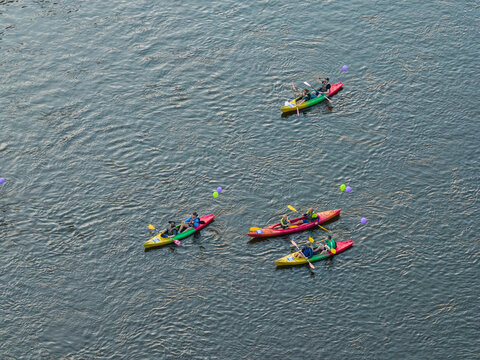Aerial view of people paddling in colorful kayaks on the Neris River with floating balloons in Vilnius, Vilnius County, Lithuania.