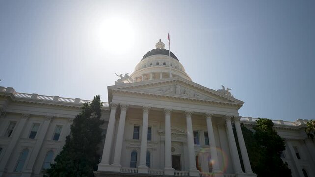Sunrise casts light on the Capitol in Sacramento, showcasing the structure and its surroundings in a new day.