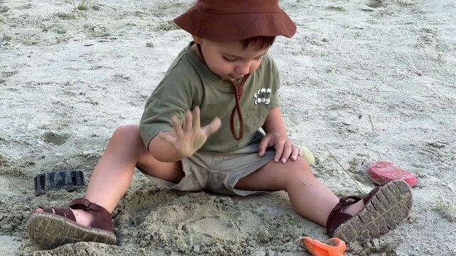 Toddler playing with sand on beach