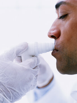 Lung function test medical professional gloved hand patient peak flow meter breathing test respiratory test lung test clinical setting white background close up profile view side view face