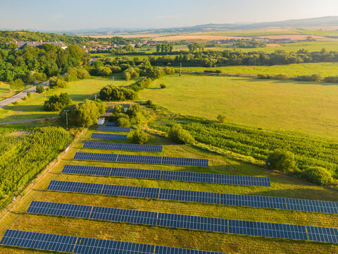 Aerial view of a solar farm with rows of photovoltaic panels set in a green rural landscape near Viglas castle in Viglas, Banska Bystrica Region, Slovakia.