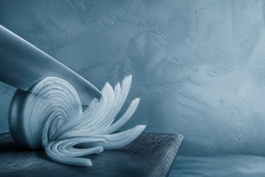 Blue toned onion slicing still life on cutting board