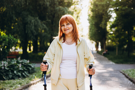 Mature woman enjoying nordic walking in park
