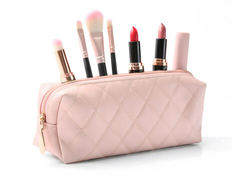 Elegant pink quilted cosmetic bag filled with various professional makeup brushes and colorful lipsticks on a clean white background for beauty and fashion concepts