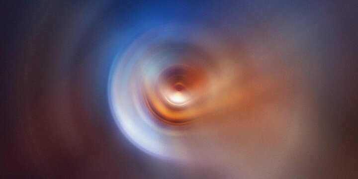 Abstract cosmic vortex background with vibrant orange and blue swirling circular motion blur.