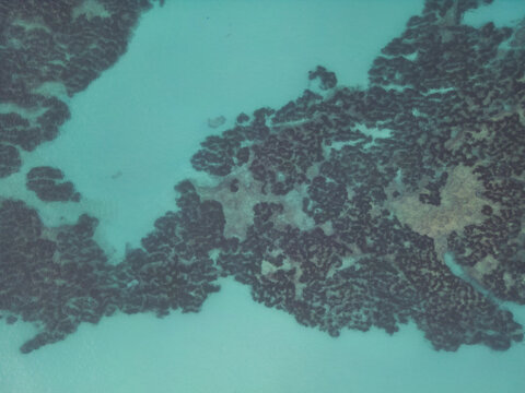 Aerial view of rocky reef formations and clear turquoise water in Moraira, Valencian Community, Spain.