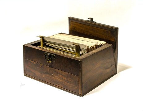 Vintage wooden filing box with brass hardware containing sorted index cards
