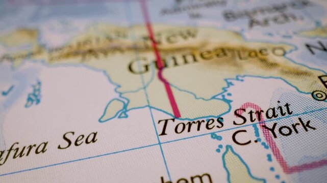Gliding macro view over physical atlas map from Gulf of Carpentaria to New Guinea