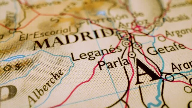 Gliding macro view over atlas map leading to Madrid, Spain