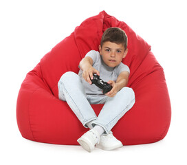 Boy with controller playing video game on bean bag against white background © New Africa