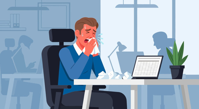 Office Worker Suffering From a Cold Sneezing While Working At His Desk in Office
