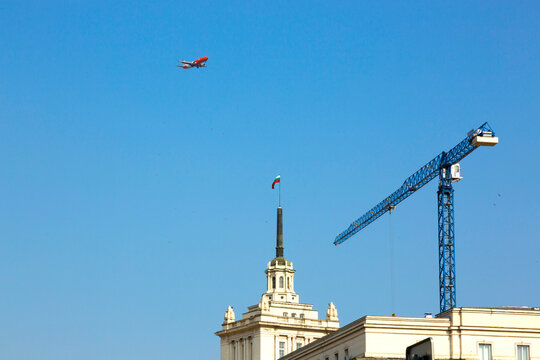 Sofia, Bulgaria - August 09, 2017: Airplane and crane over the building of Council of Ministers of Bulgaria in Sofia