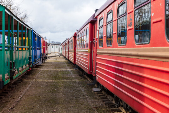 View of the historic Aukstaitija narrow gauge railway with colorful red and green passenger carriages parked on the tracks in Panevezys, Panevezio apskritis, Lithuania.