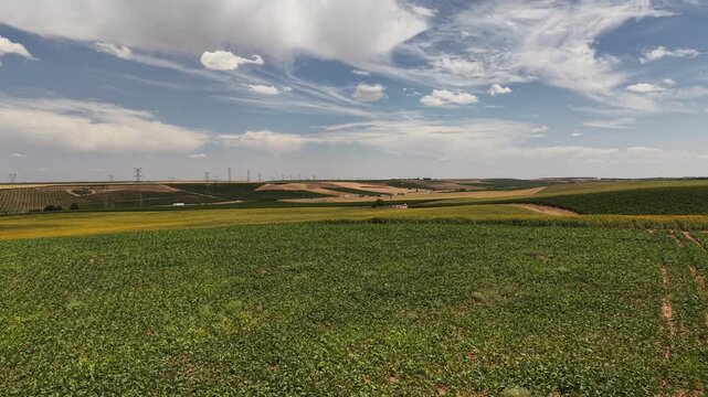 Aerial view of green farmland and wind turbines in rueda, spain