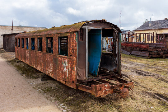 View of a rusted, abandoned railway carriage from the historic Aukstaitija narrow gauge railway, with peeling paint in a rail yard in Panevezys, Panevezio apskritis, Lithuania.